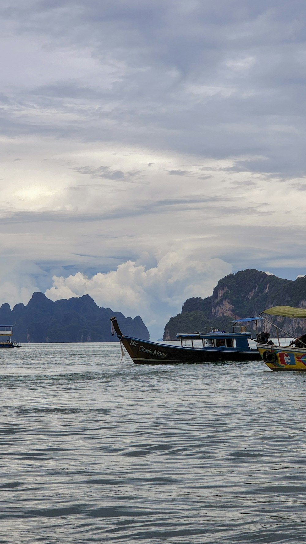 a couple of boats floating on top of a large body of water