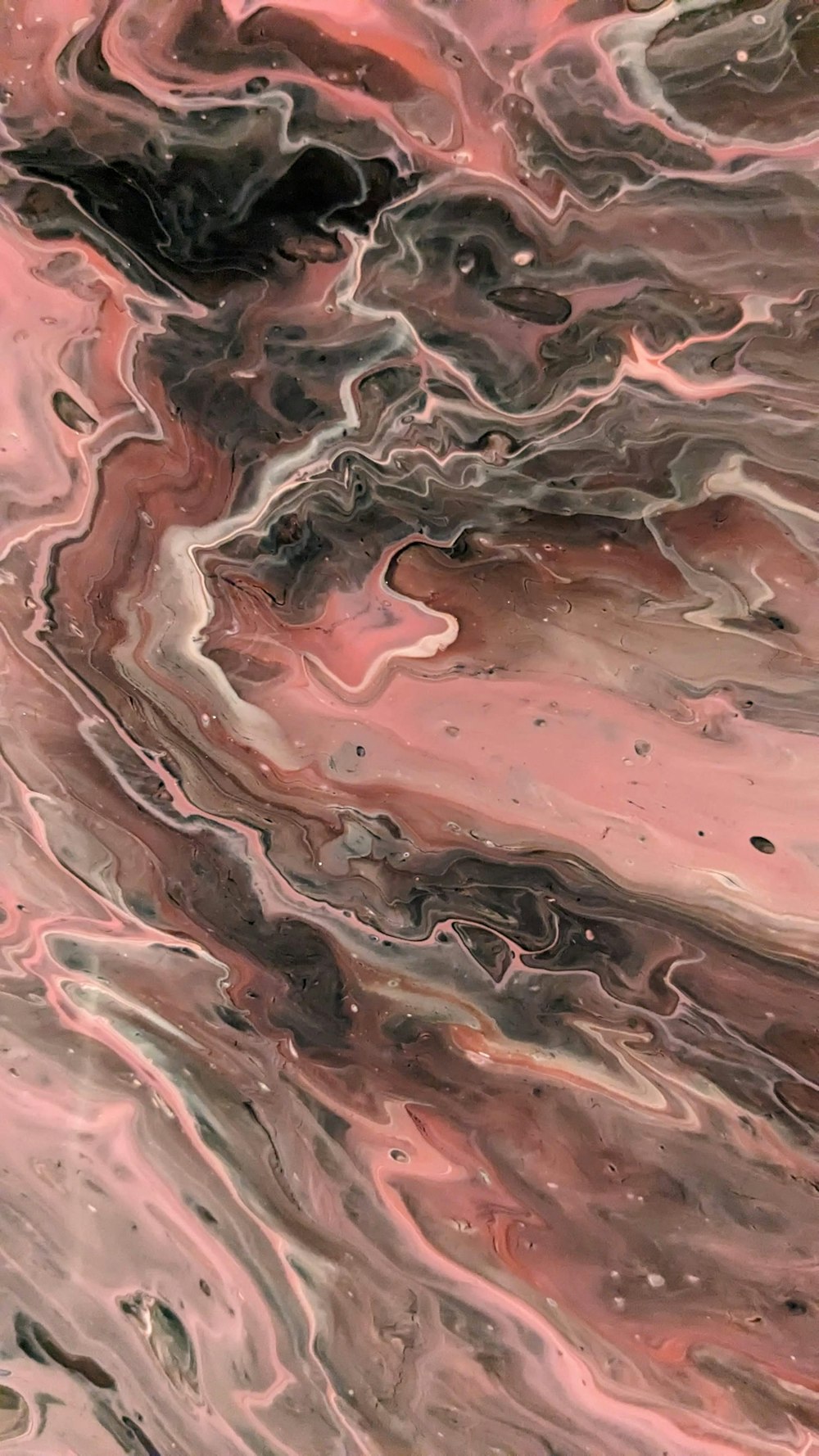 a close up of a pink and black marble