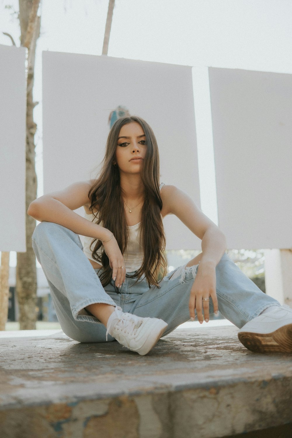 a young woman sitting on the ground with her legs crossed