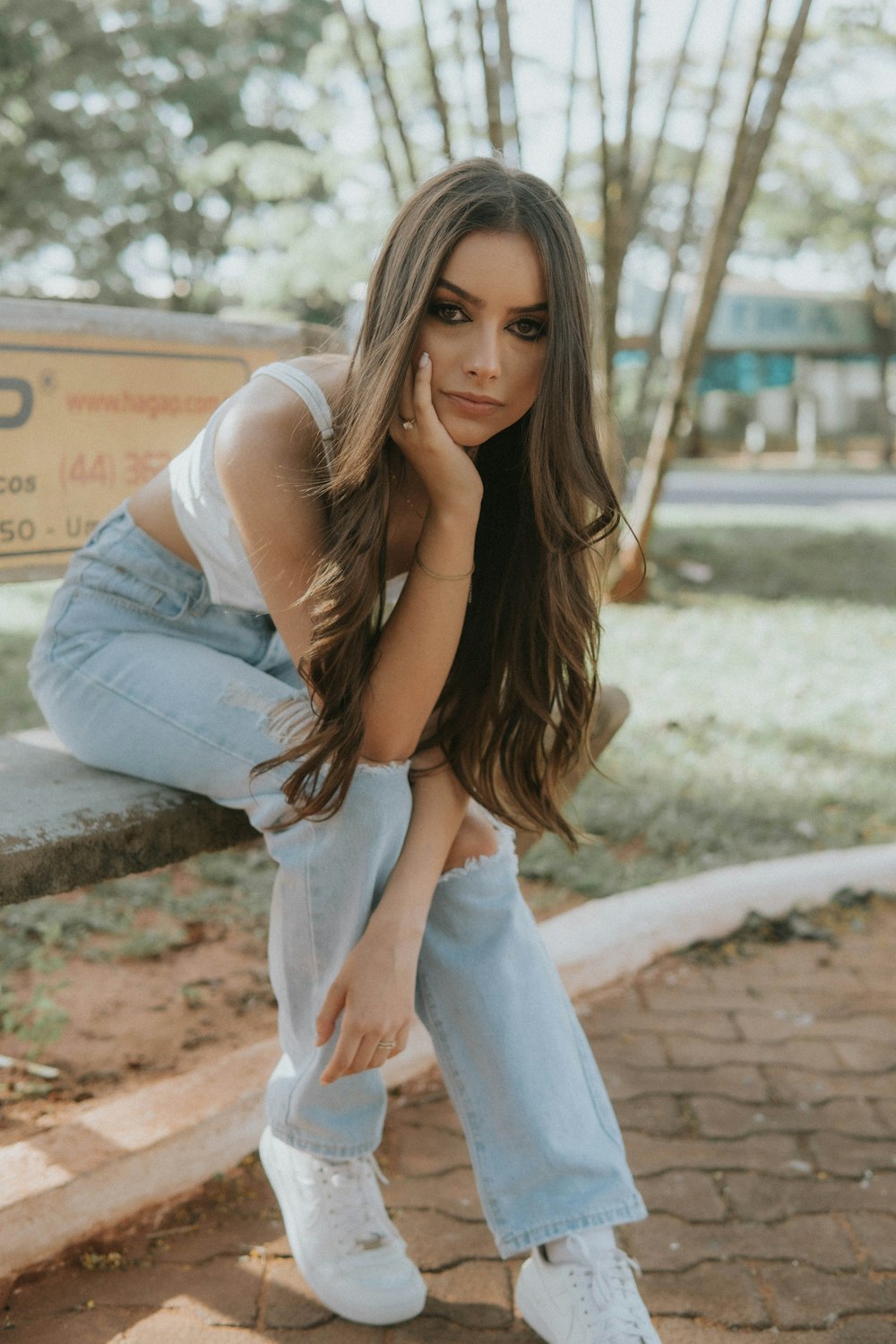 a woman sitting on a bench in a park