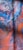 Abstract artwork featuring swirling patterns of vibrant colors including deep blues, fiery oranges, and splashes of red. The surface displays a marbled effect with intricate textures resembling bubbles or foam near the top.