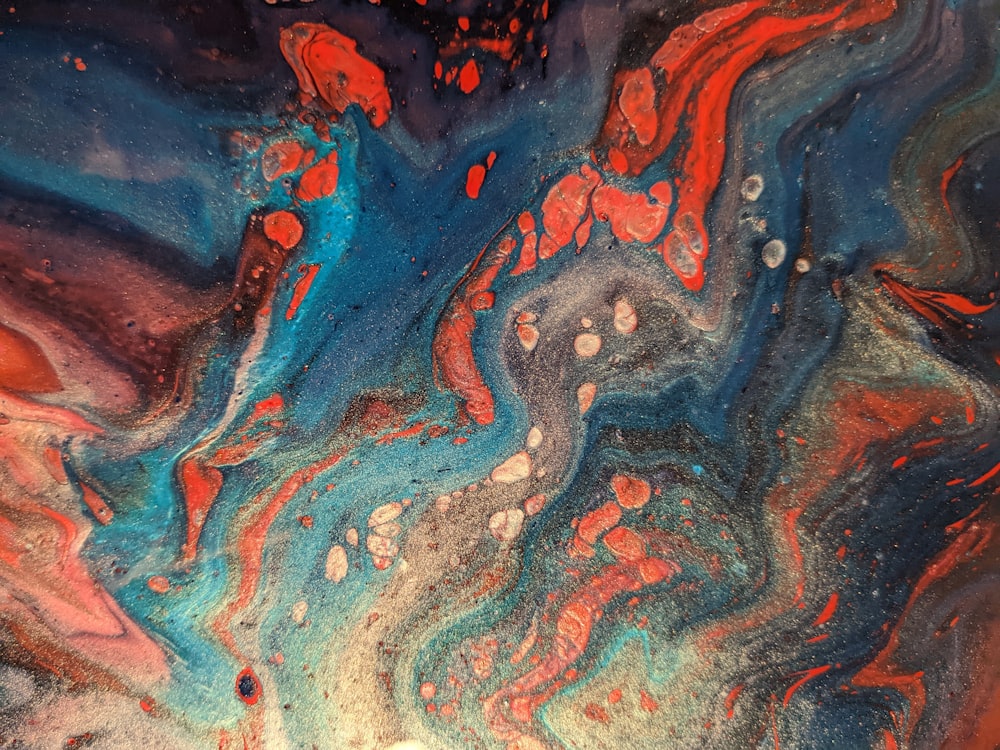 a close up of an abstract painting with red and blue colors