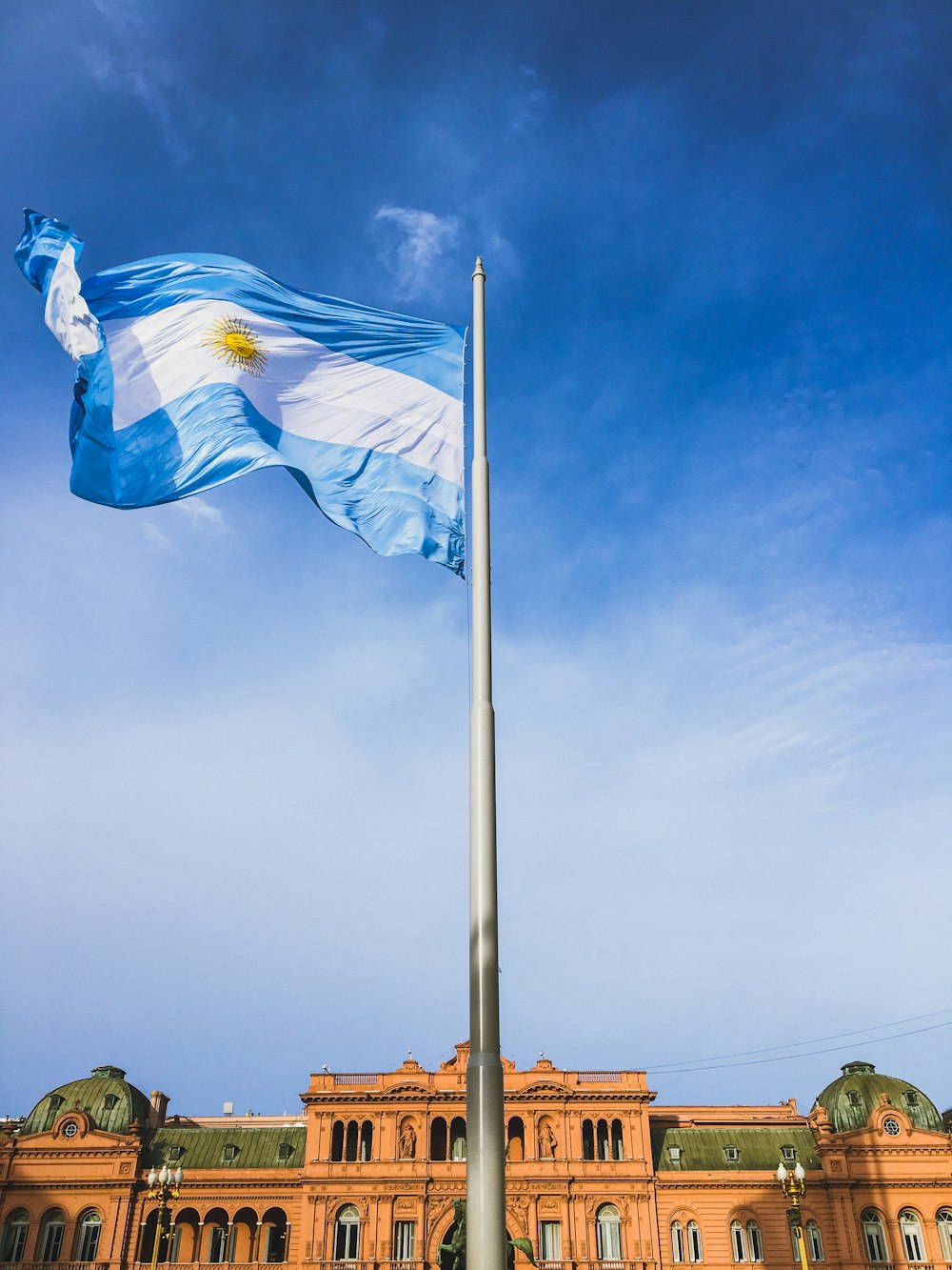 Una bandera ondeando frente a un gran edificio