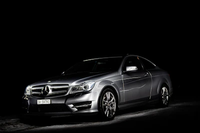 Black luxury car with glossy finish under cinematic lighting.