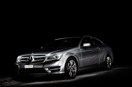A luxury car ready for an exclusive event, highlighted by sleek lines and a dark, moody background.