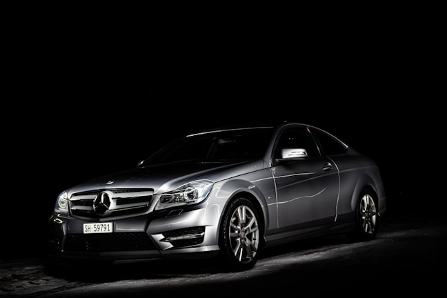 Studio shot of a sleek luxury car with soft, dramatic lighting on an off-white background.