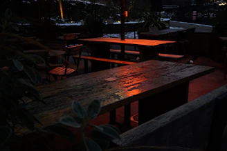 A softly lit outdoor patio featuring minimalist furniture and ambient yellow lighting creating a relaxing vibe.