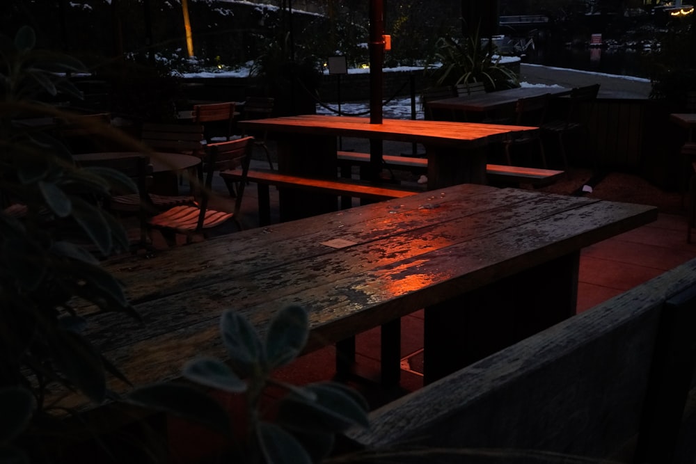 a wooden table sitting under an umbrella at night