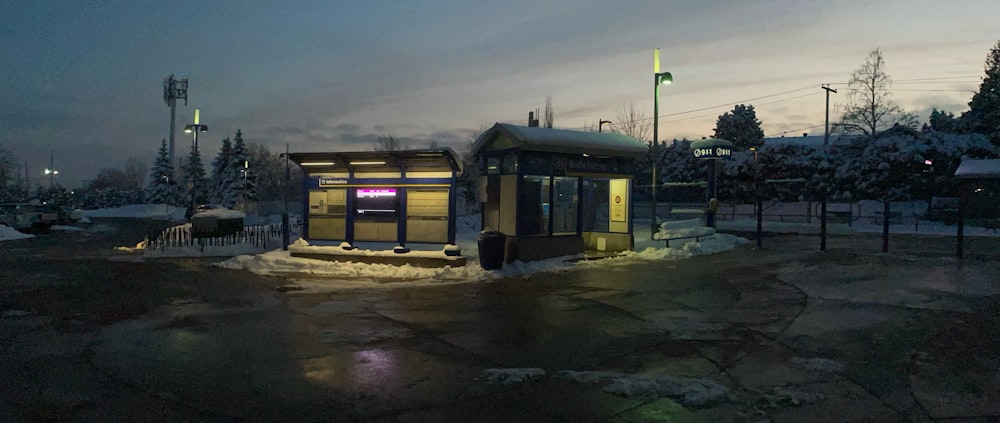 a small bus stop in the middle of a snowy field