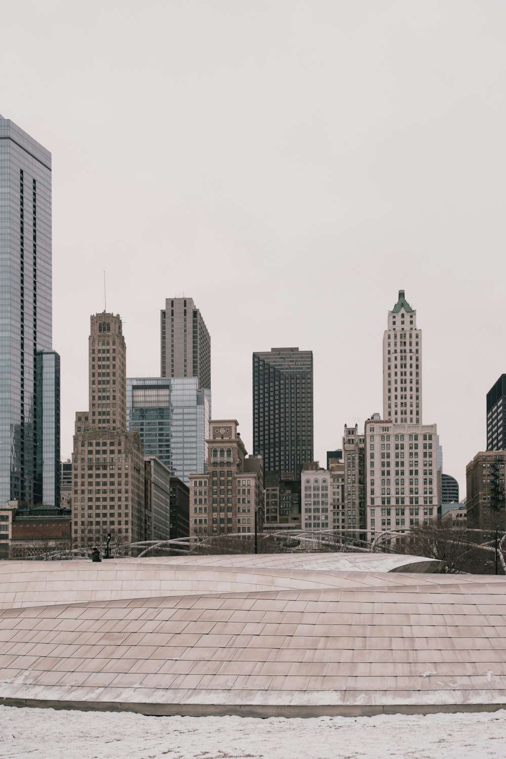 a city skyline with tall buildings and snow on the ground