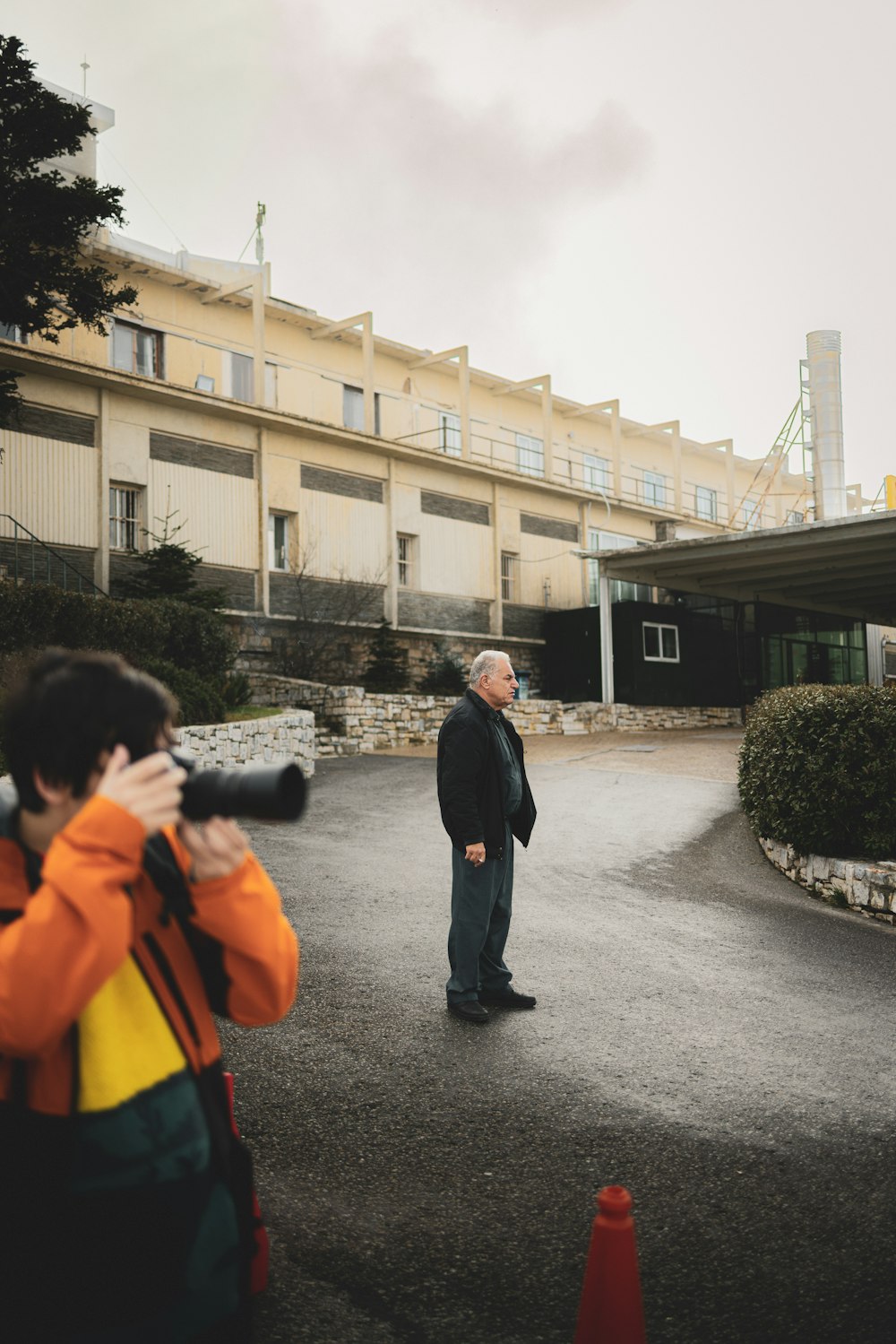 a man standing in a parking lot with a camera