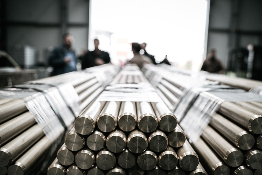 a group of people standing around a pile of metal rods