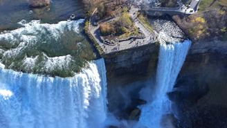 an aerial view of a waterfall and a bridge