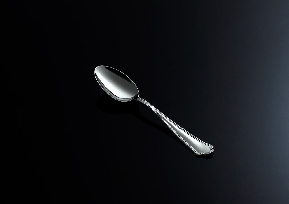 a silver spoon on a black surface