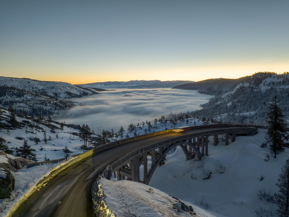 a train traveling over a bridge in the snow