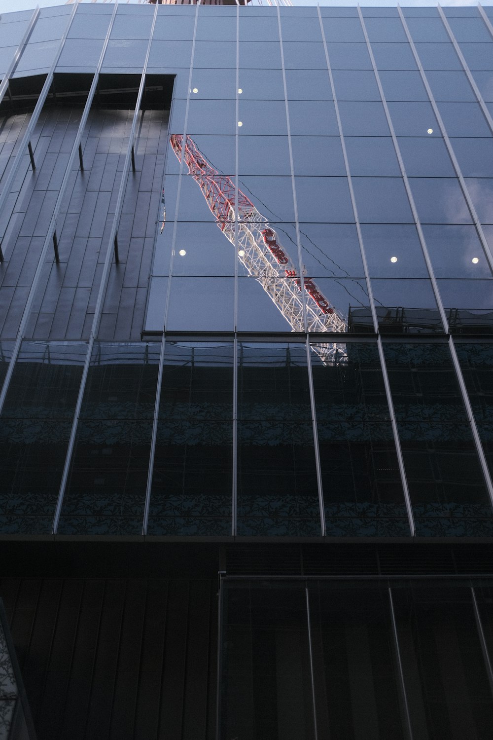 a crane is reflected in the windows of a building