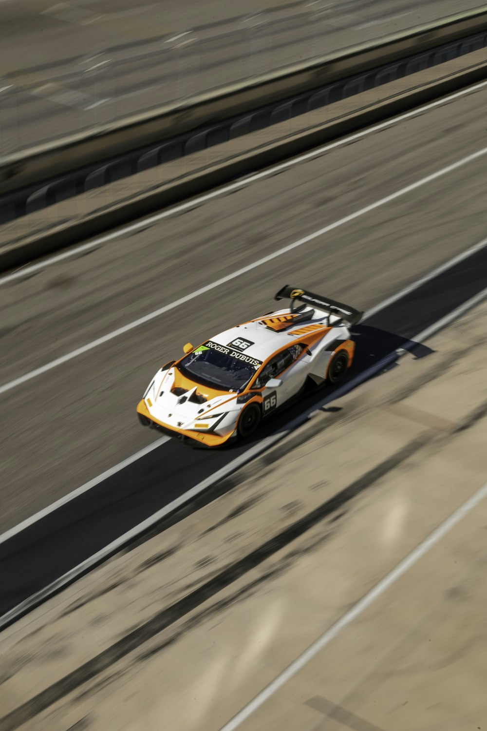 a white and orange race car driving down a highway