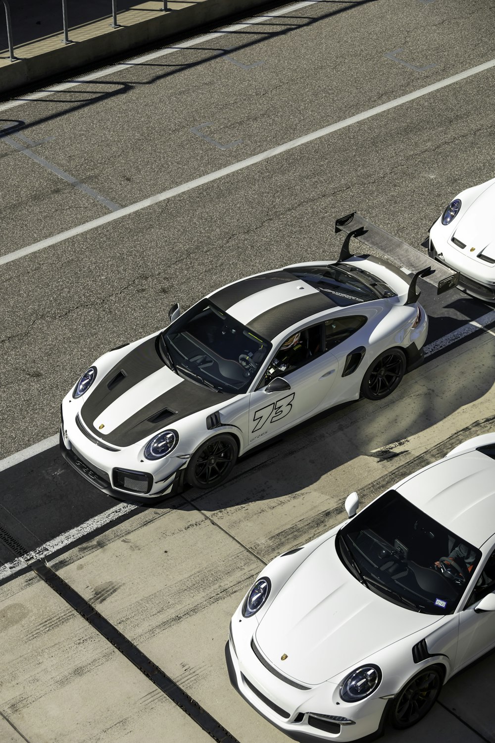 two white sports cars parked next to each other