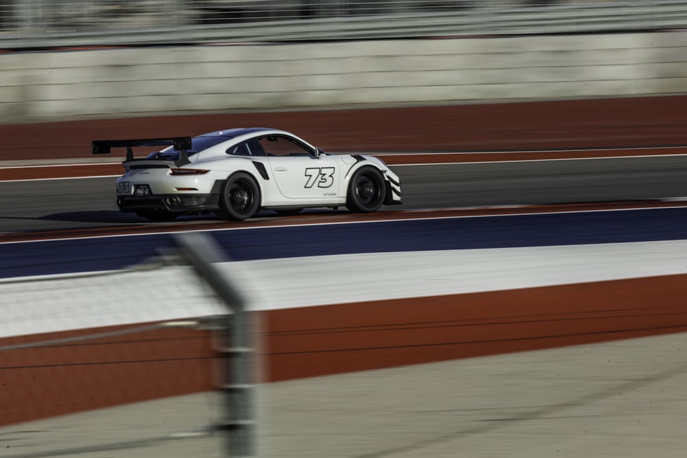 a white car driving down a race track