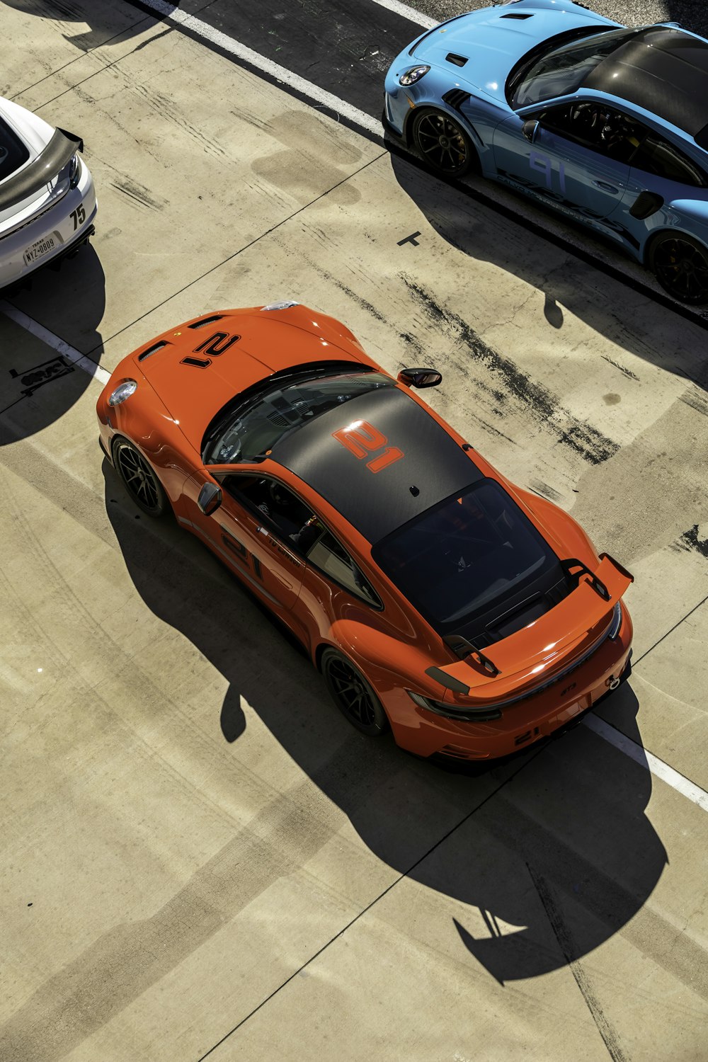 an orange sports car driving down a street