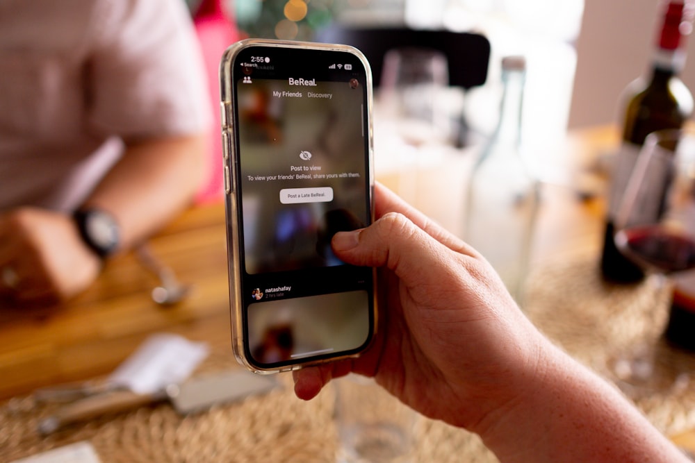 une personne tenant un téléphone cellulaire à la main