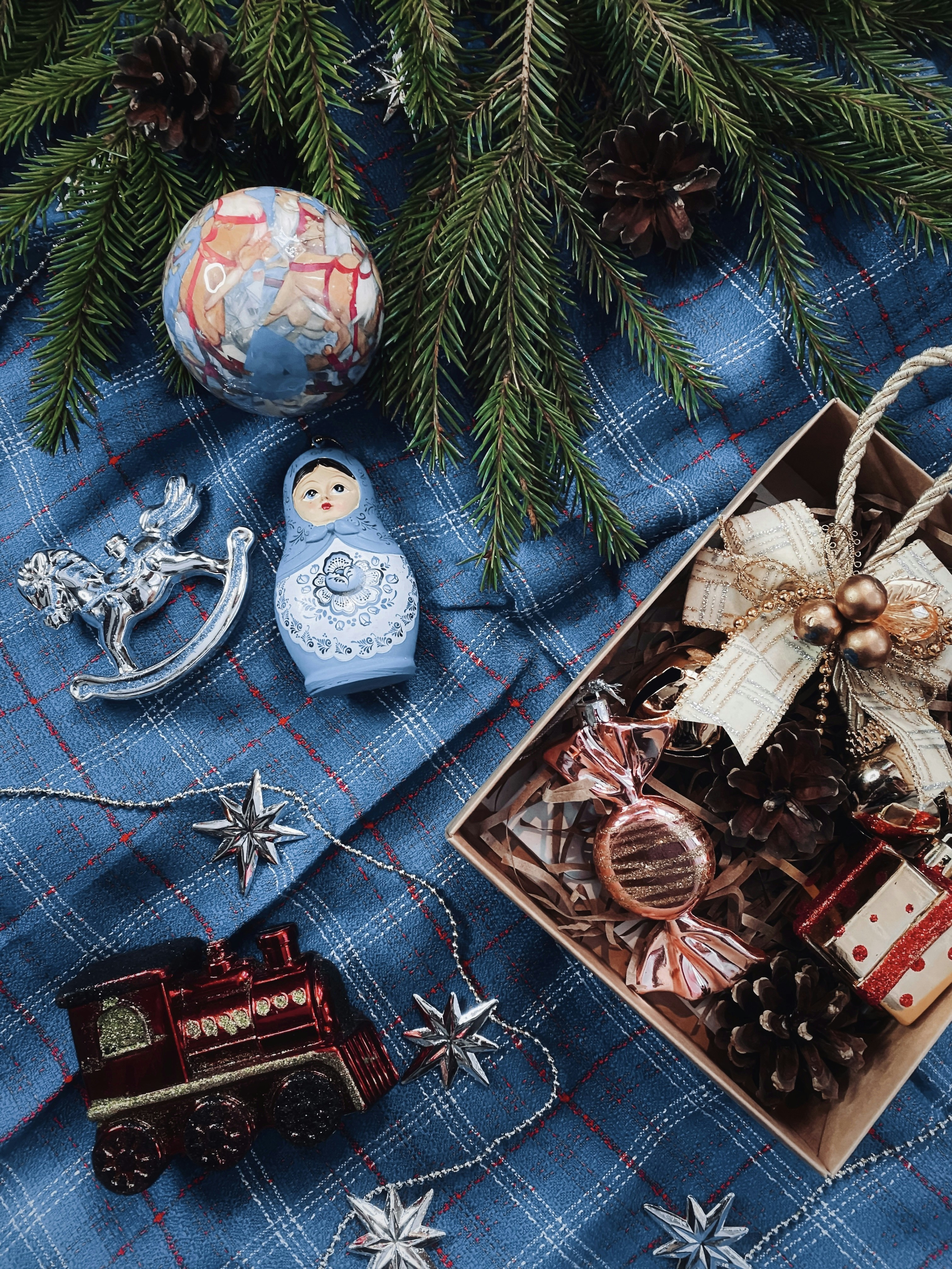 A wooden box filled with christmas decorations next to a christmas tree