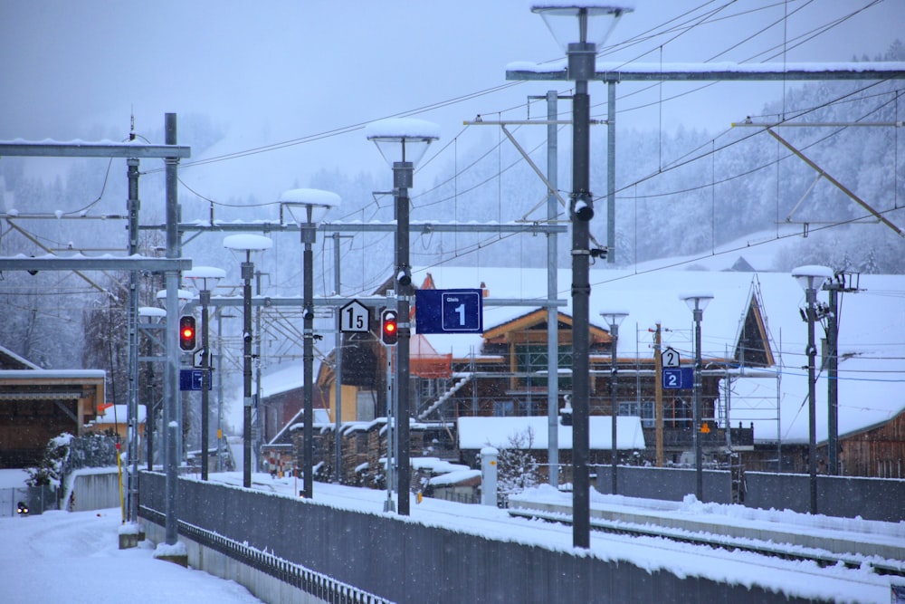 a train traveling down train tracks next to a snow covered hillside