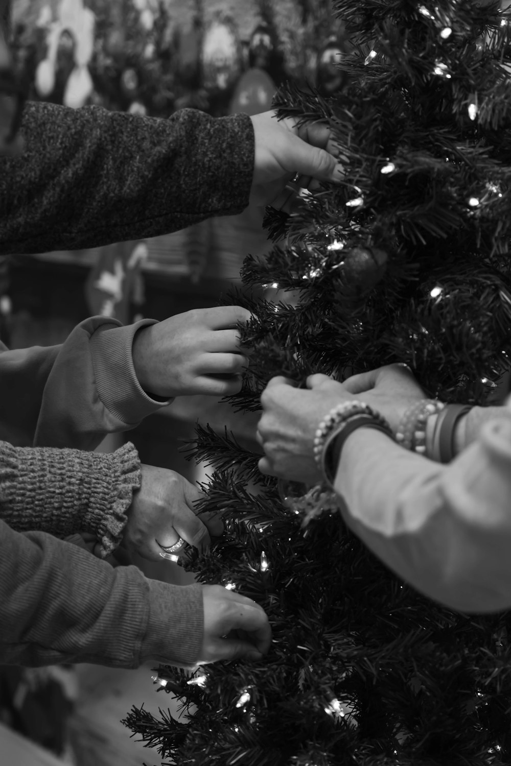 a group of people putting decorations on a christmas tree