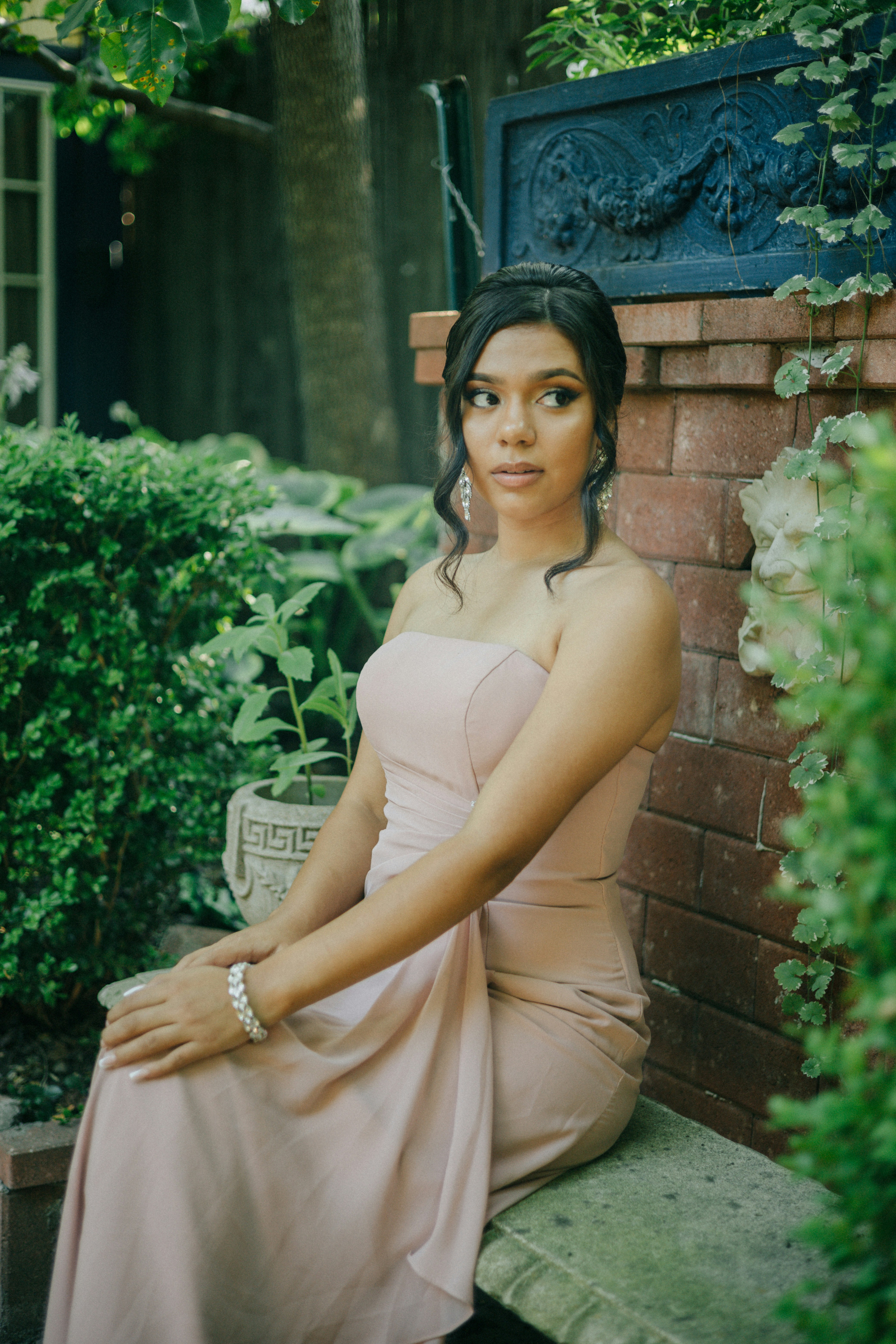 a woman in a pink dress sitting on a bench