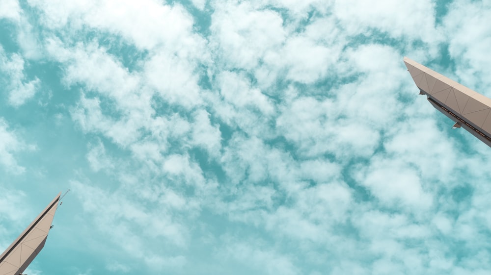 a couple of tall buildings under a cloudy blue sky