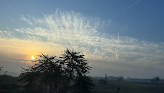 A vibrant sunrise over a peaceful new earth landscape.