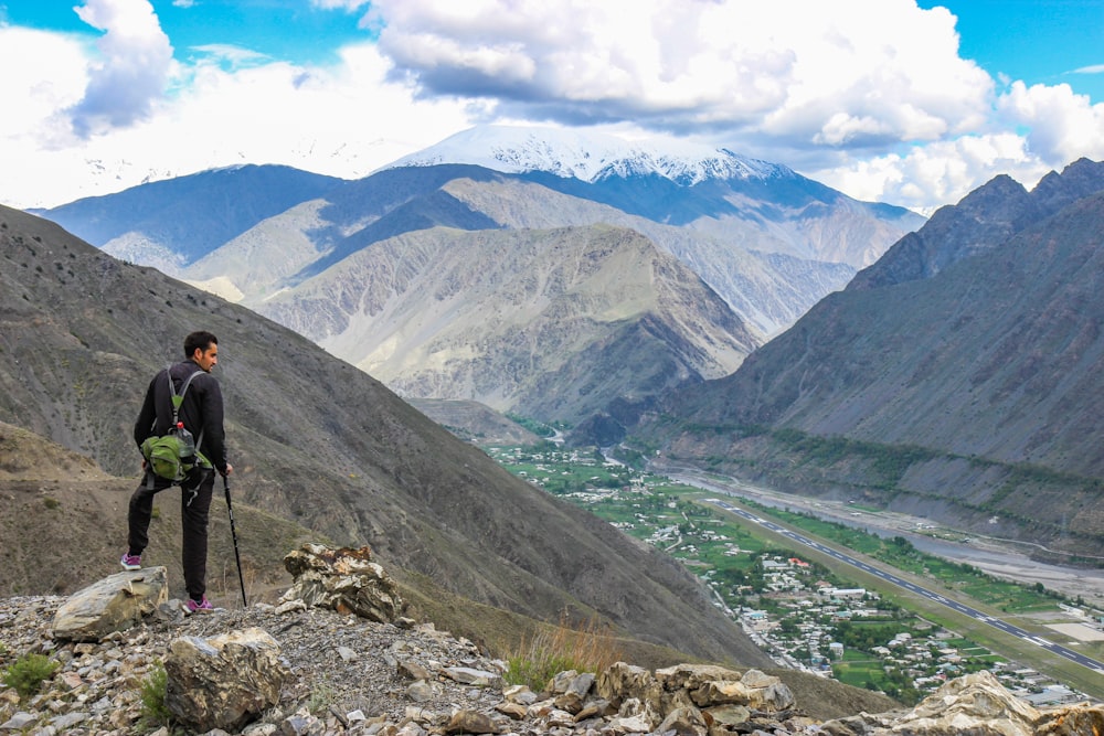 a man standing on top of a mountain with a backpack