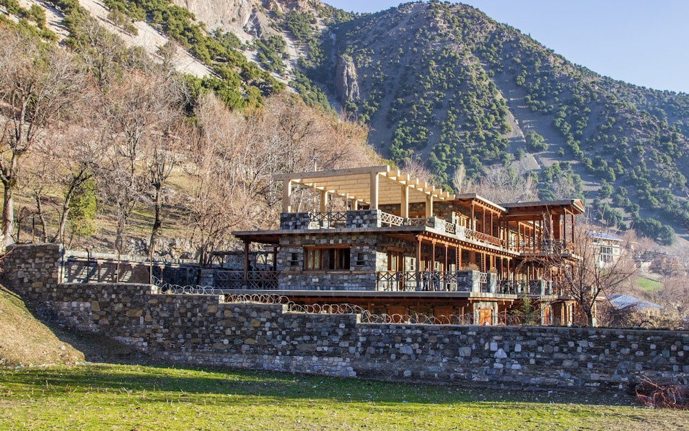 a stone wall and a house with a mountain in the background