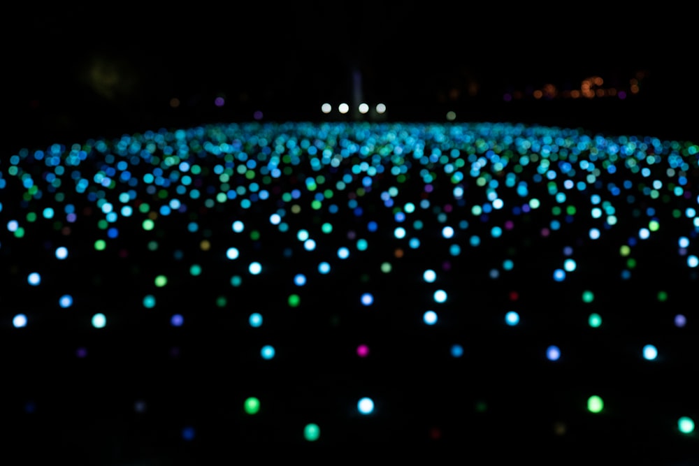 um campo cheio de luzes coloridas no escuro