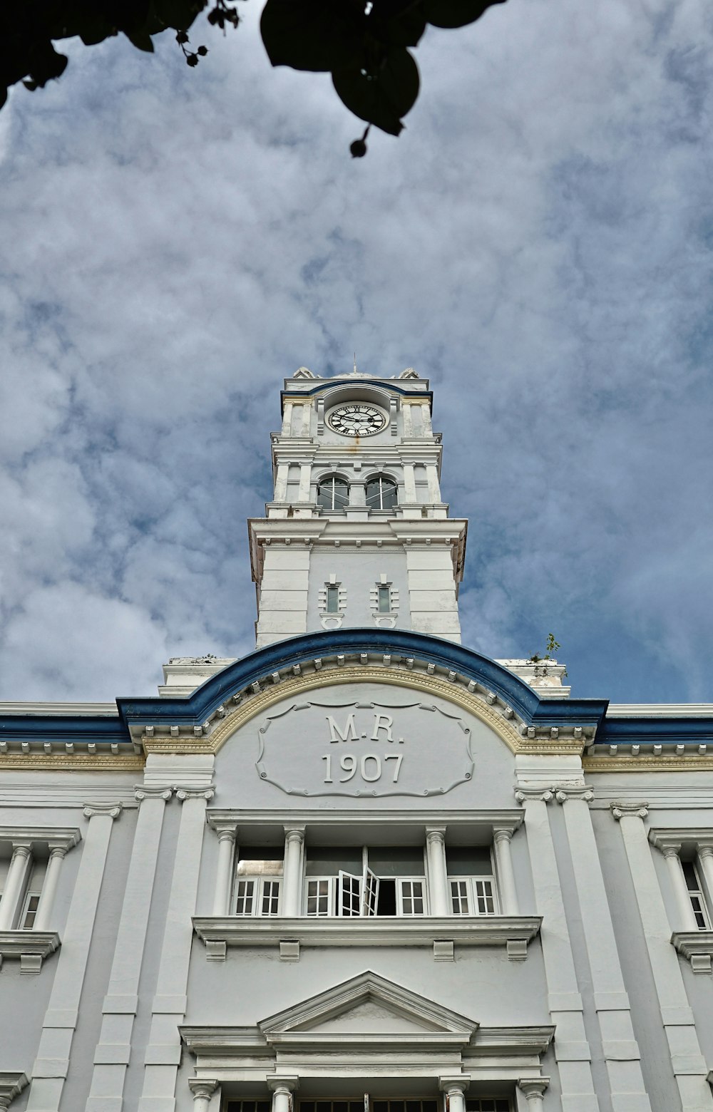 Un alto edificio bianco con una torre dell'orologio