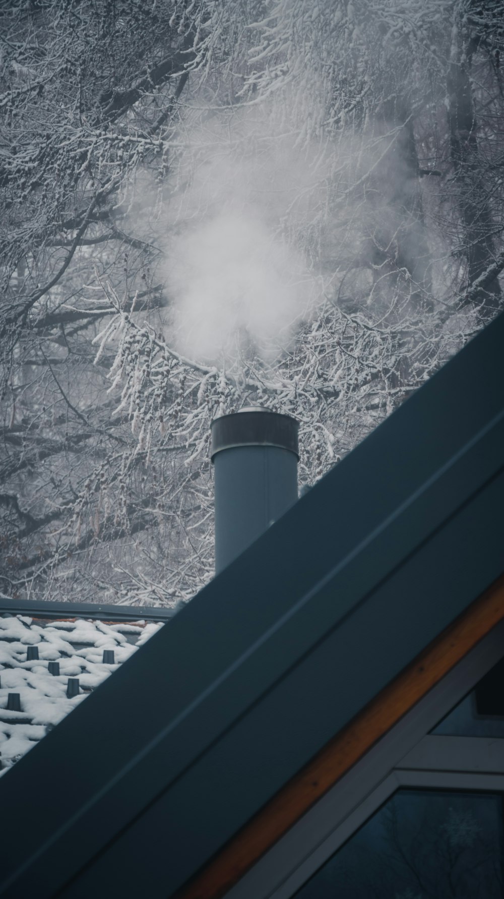 Rauch kommt an einem verschneiten Tag aus einem Schornstein