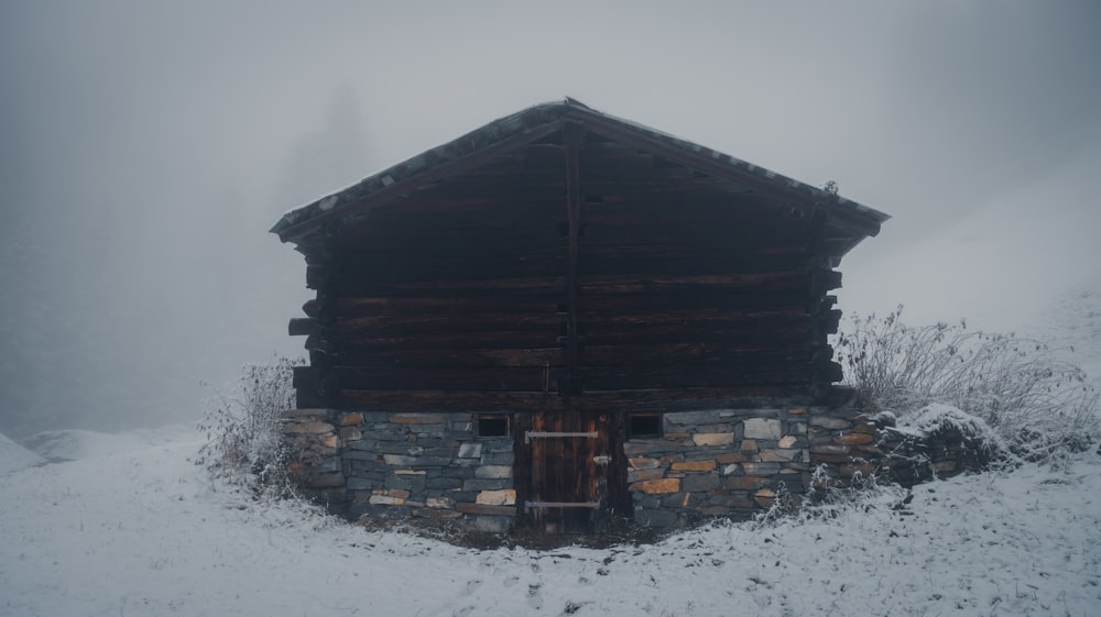 a cabin in the middle of a snowy field