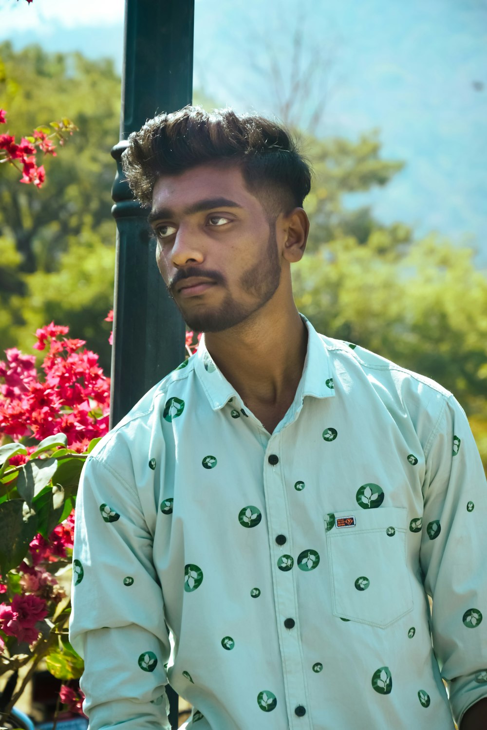 a man sitting on a bench in front of flowers