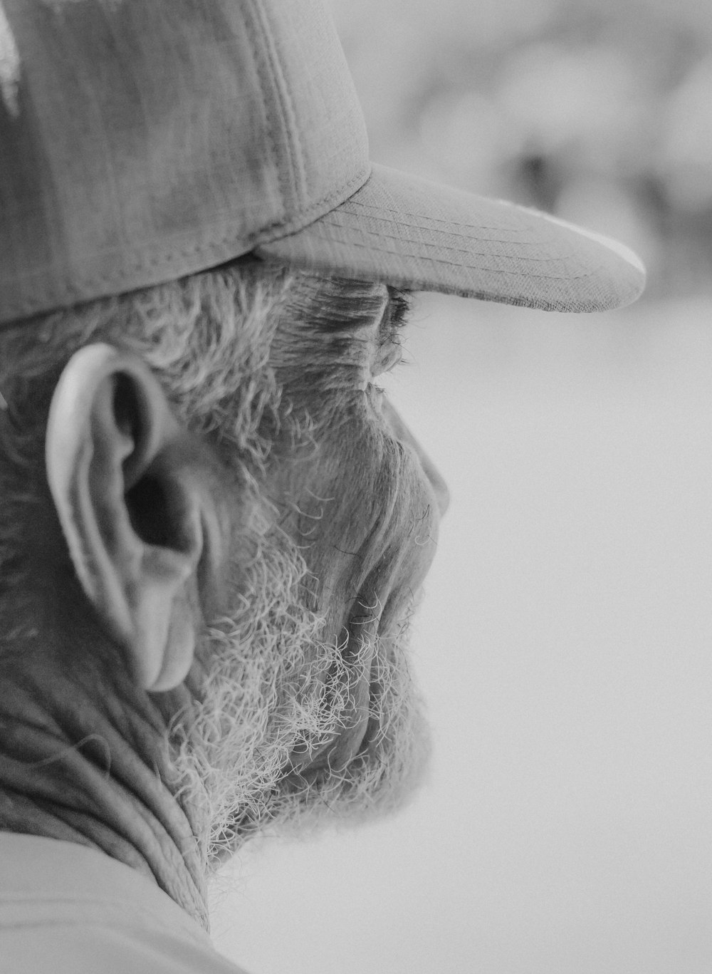 a black and white photo of a man wearing a hat