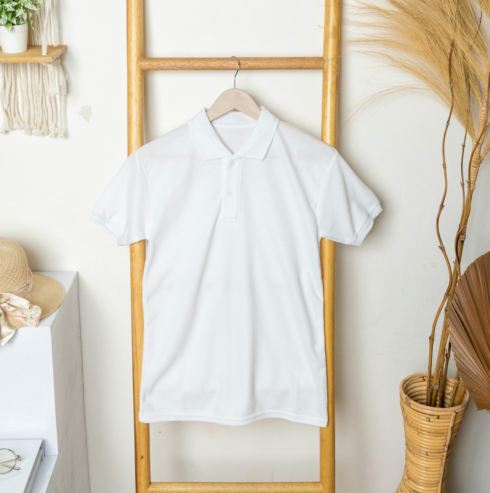 a white polo shirt hanging on a clothes rack