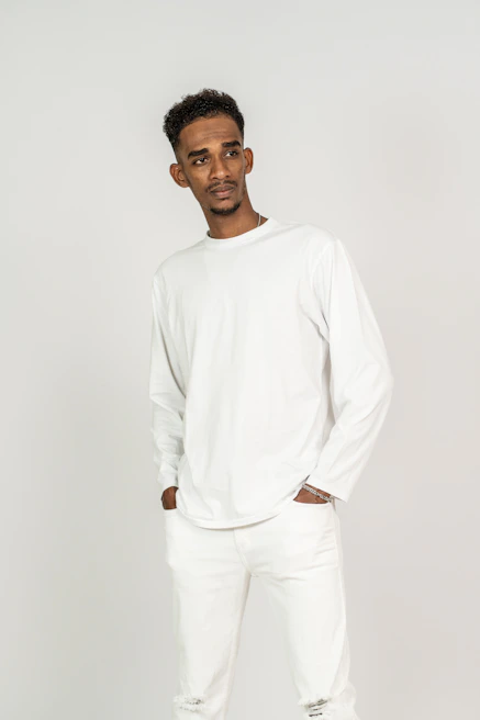 Model wearing a crisp white classic shirt paired with slim black trousers against a minimalist backdrop