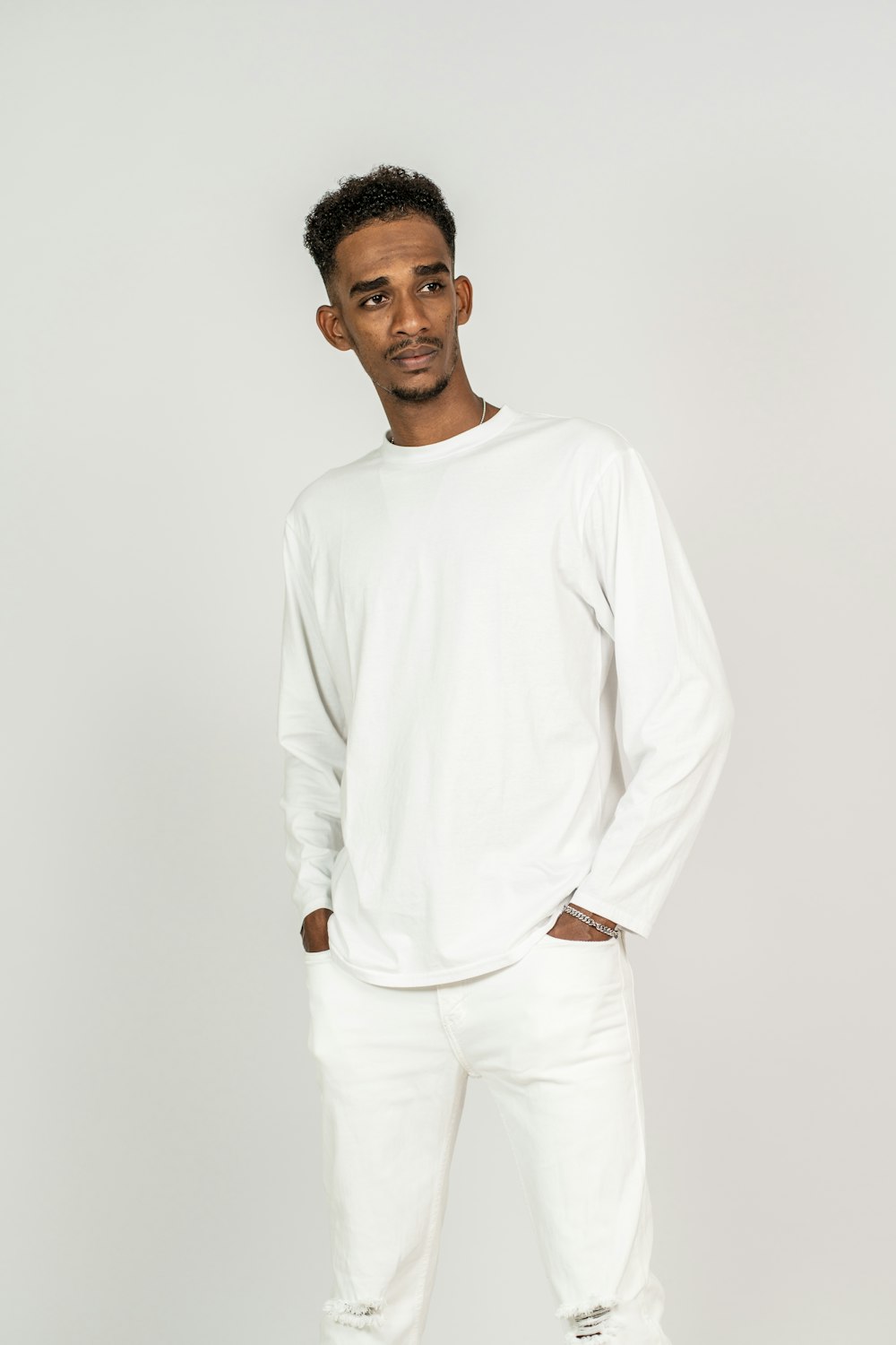 a man standing in a white shirt and jeans