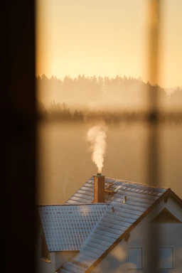 A cozy Liverpool home with a chimney gently releasing smoke against a soft evening sky.