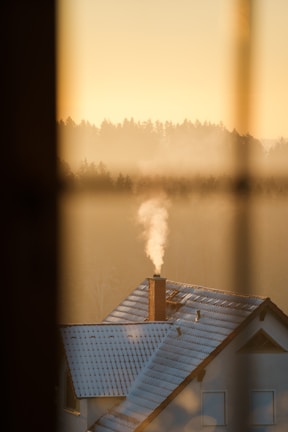 Evening view of a cozy home with a freshly serviced chimney glowing softly.