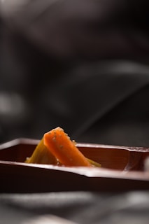 A handful of glossy chia seeds scattered over a burnt orange cloth, catching the light.