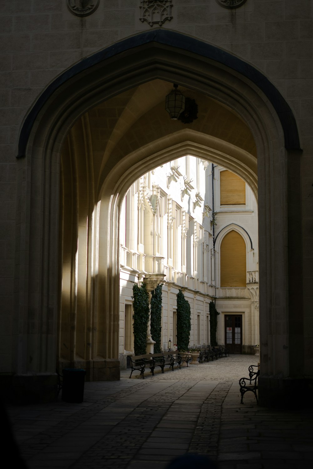 an archway leading into a building with benches
