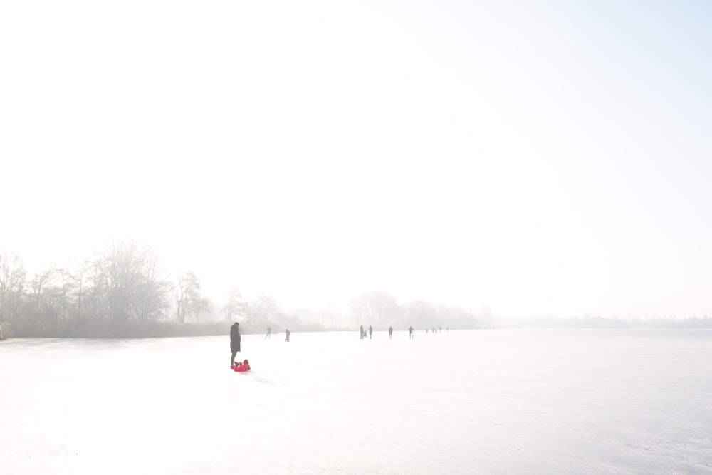 a group of people walking across a snow covered field