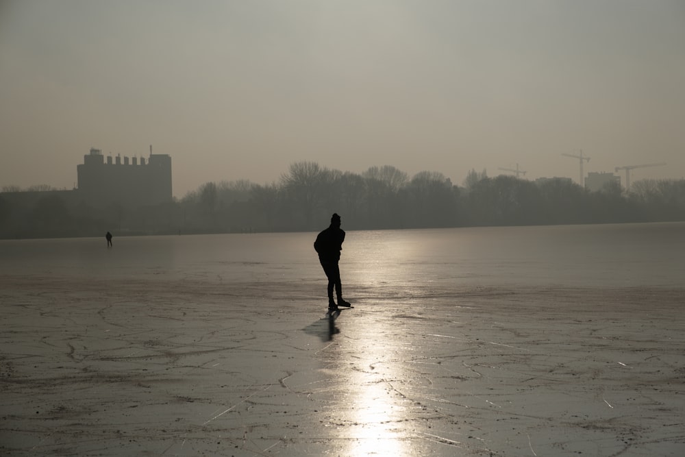 Una persona in piedi nel mezzo di un lago ghiacciato