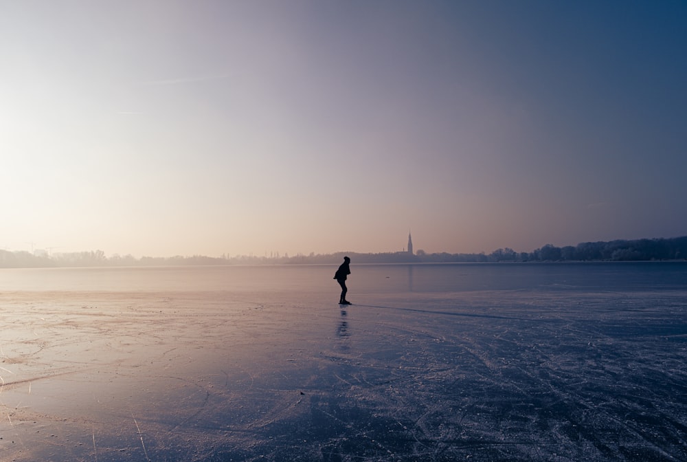 a person is standing on a frozen lake