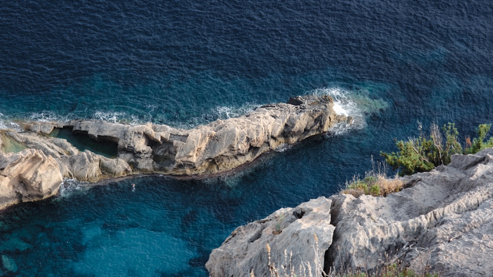 an aerial view of a body of water next to a rocky cliff